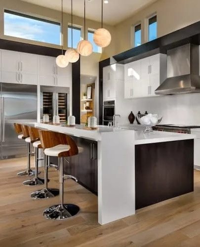 Kitchen with a white waterfall island, bar seating, and globe pendant lights