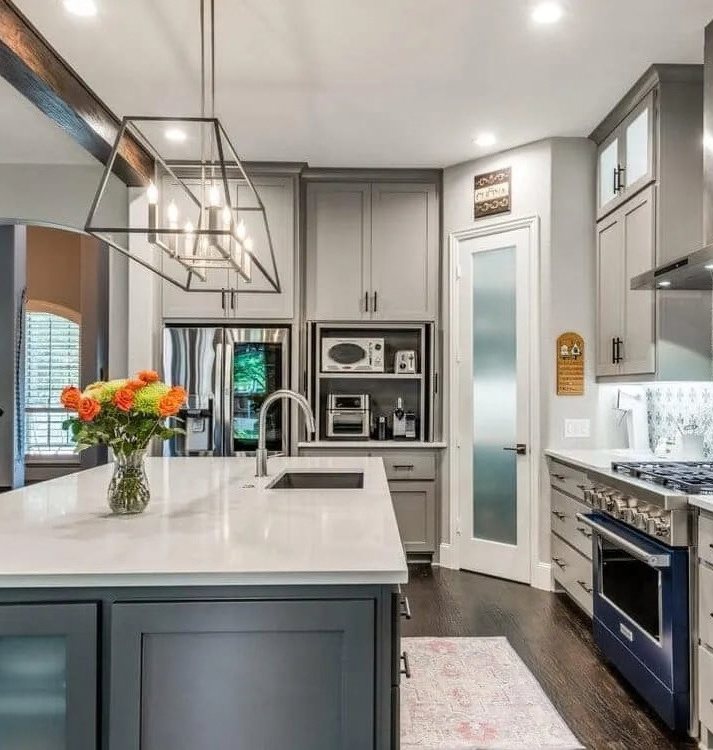 Renovated kitchen with a white quartz island, gray cabinets, and a pendant light